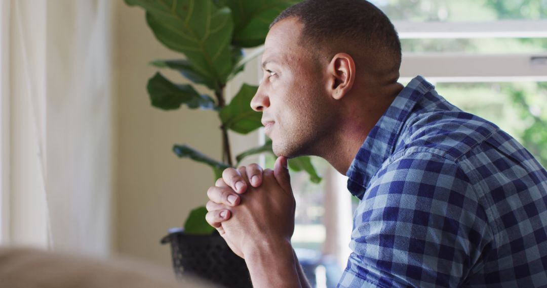 Contemplative Man Looking Out Window in Peaceful Home Setting