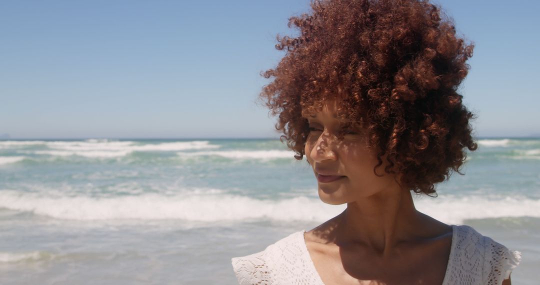 Woman with Curly Hair Enjoying View at Beach - Free Images, Stock Photos and Pictures on Pikwizard.com