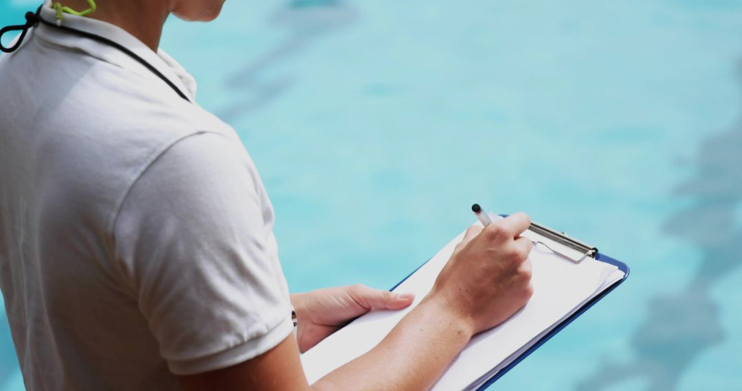 Lifeguard Conducting Safety Checks by Poolside with Clipboard