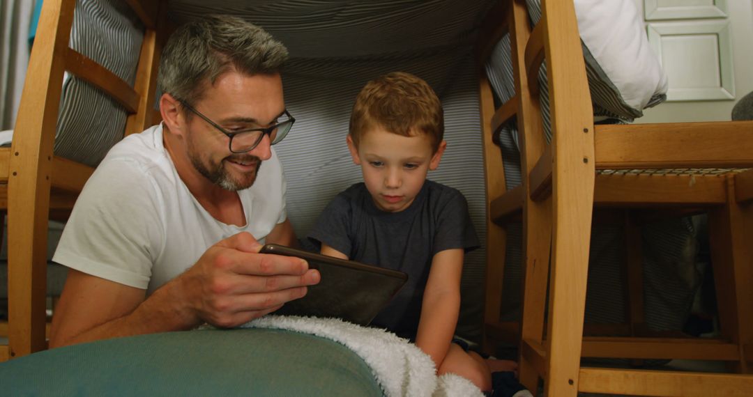 Father and Son Building Blanket Fort and Using Tablet - Free Images, Stock Photos and Pictures on Pikwizard.com