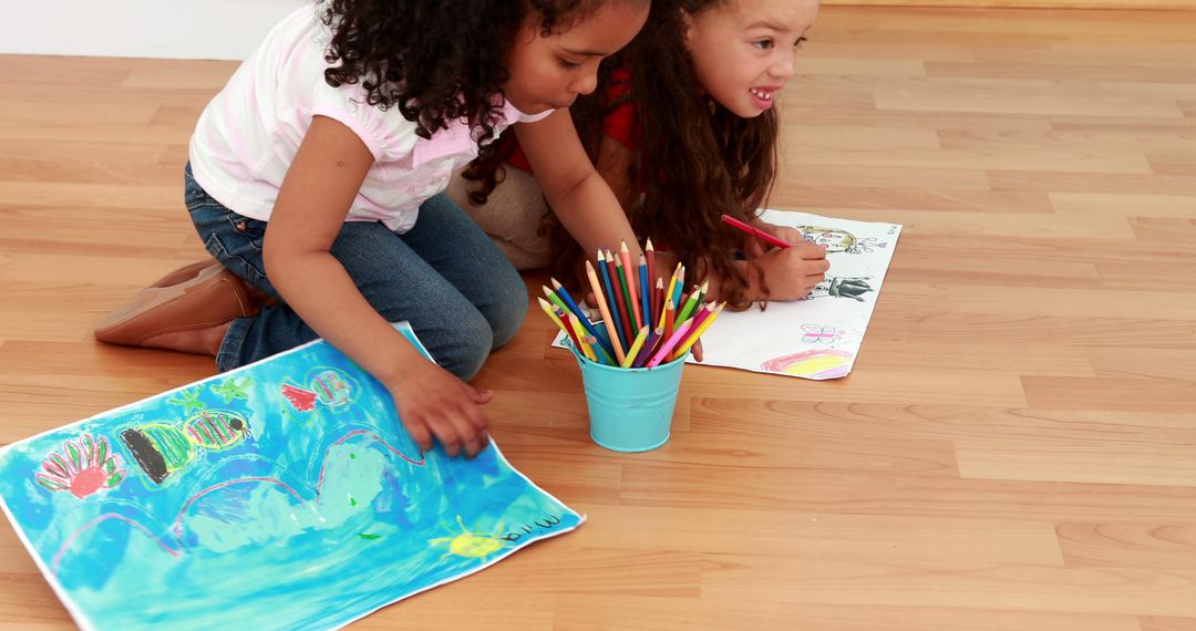 Two Young Girls Drawing on Floor with Colorful Pencils and Artworks - Free Images, Stock Photos and Pictures on Pikwizard.com