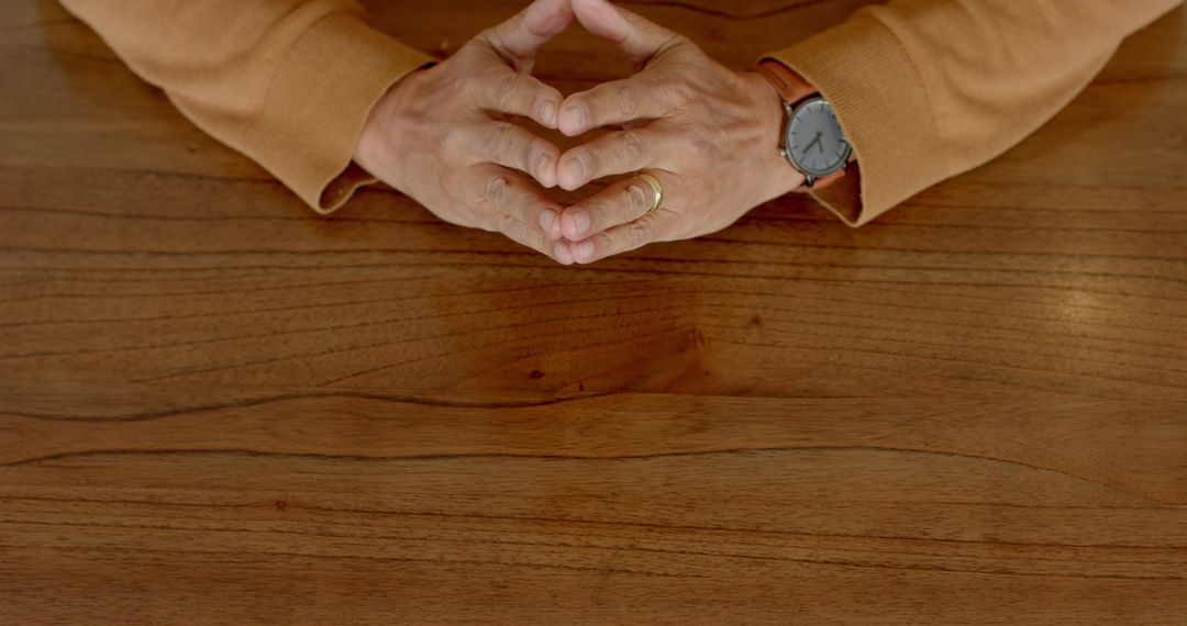 Hands Forming Gesture on Wooden Table Highlighting Communication Concept