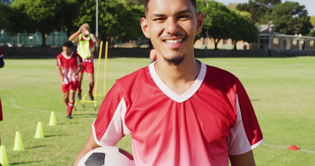 Smiling Young Male Soccer Player Holding Ball on Field - Free Images, Stock Photos and Pictures on Pikwizard.com