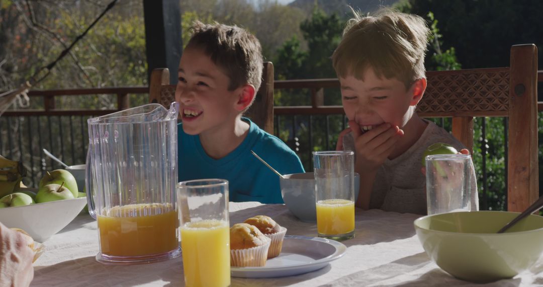 Children Laughing While Enjoying Breakfast Outdoors - Free Images, Stock Photos and Pictures on Pikwizard.com