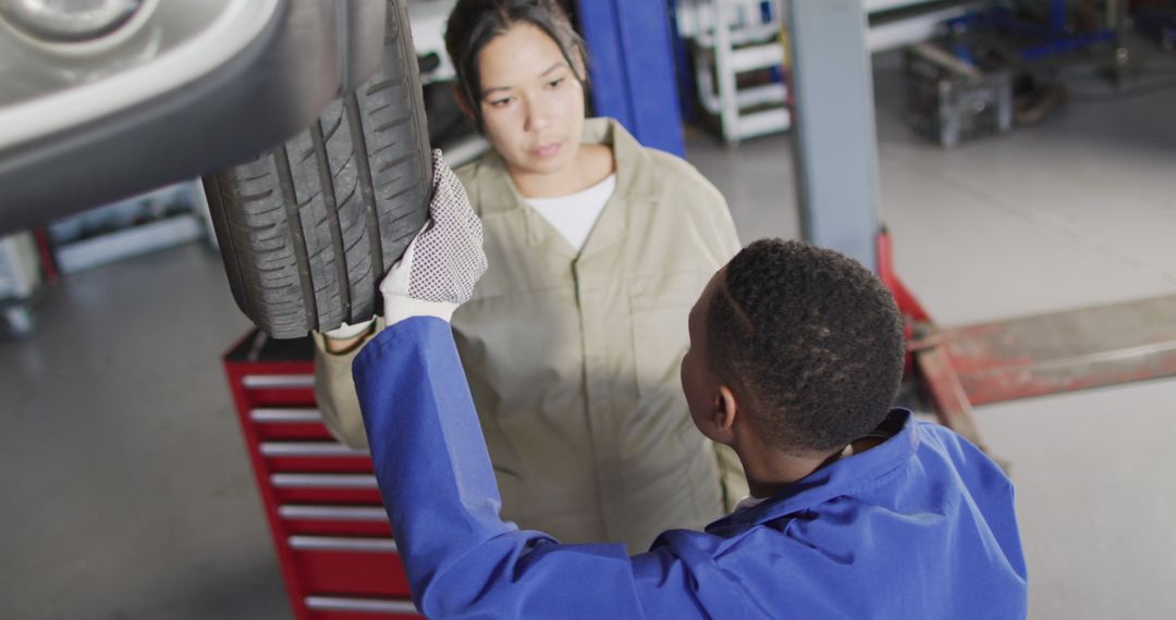 Auto Mechanics Inspecting Tire in Repair Shop - Free Images, Stock Photos and Pictures on Pikwizard.com