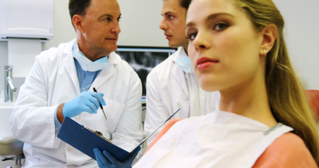 Dentist and Assistant Analyzing X-ray While Treating Female Patient - Free Images, Stock Photos and Pictures on Pikwizard.com