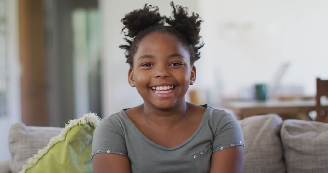 Joyful African American Girl Smiling on Sofa at Home