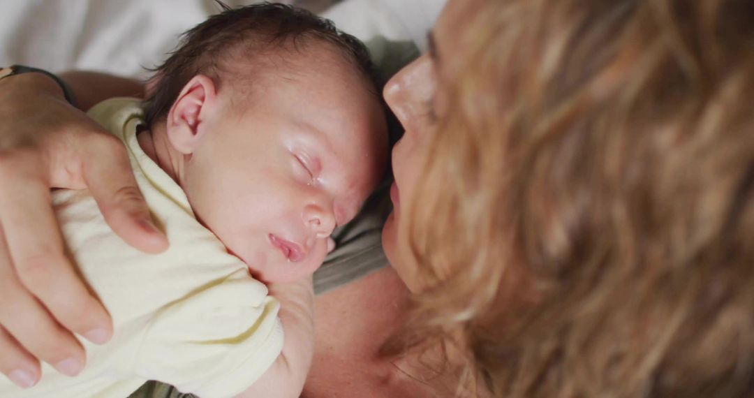 Mother Holding Sleeping Newborn with Tenderness