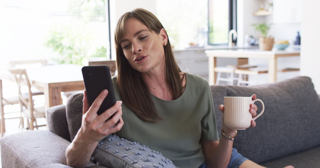 Middle-Aged Woman Relaxing with Smartphone and Coffee at Home