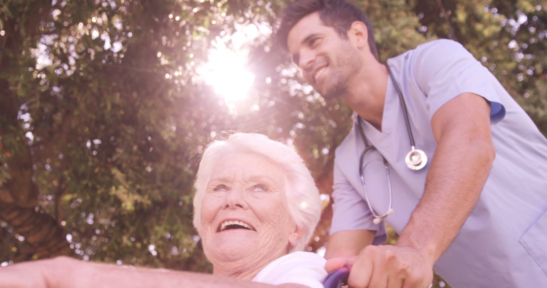 Caring Nurse Pushing Elderly Woman in Wheelchair Outdoors - Free Images, Stock Photos and Pictures on Pikwizard.com