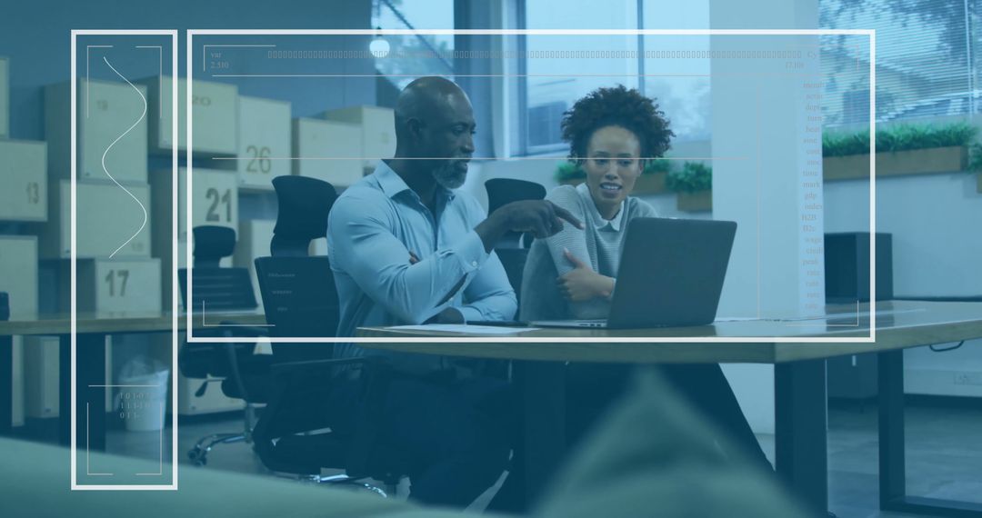 Diverse Colleagues Danalyzing Data on Laptop in Modern Office