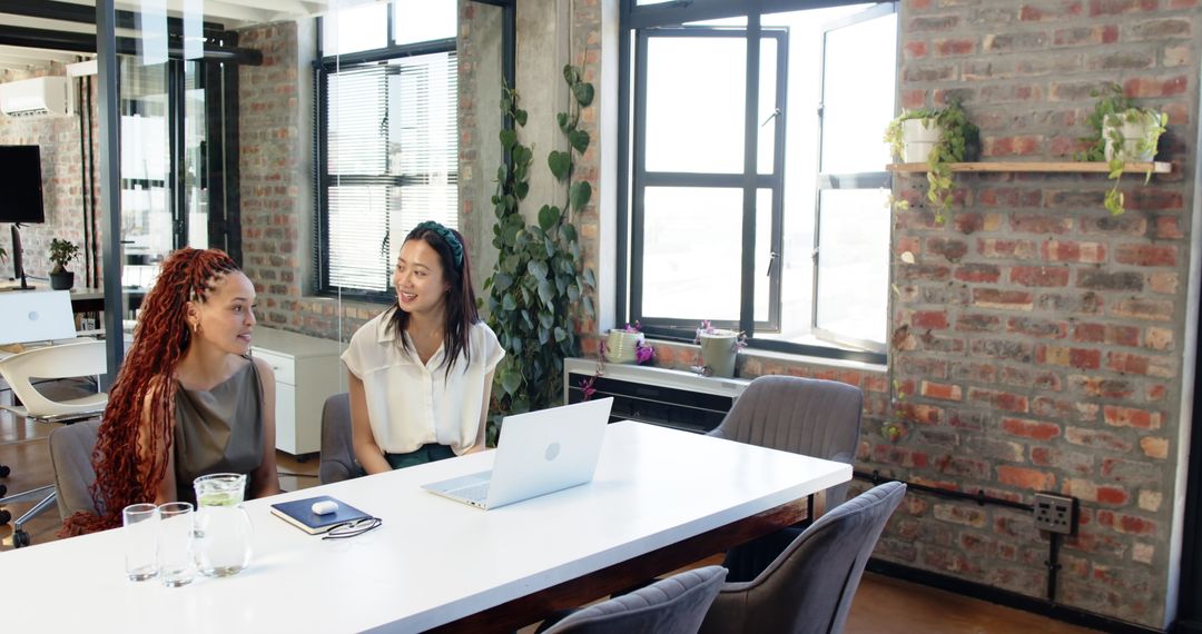 Three Female Colleagues Collaborating in Modern Office Environment