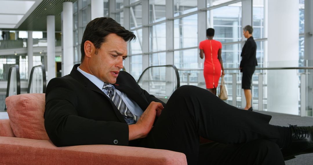 Businessman Resting on Sofa in Modern Office Lobby - Free Images, Stock Photos and Pictures on Pikwizard.com