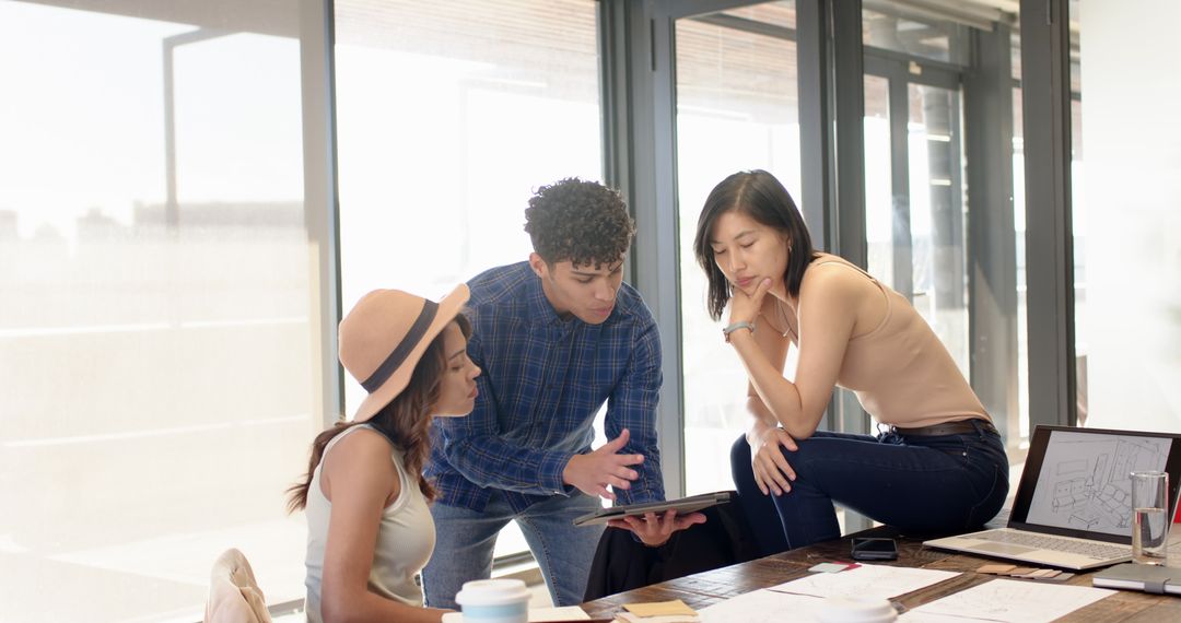 Diverse Team Collaborating on Project in Sunlit Office
