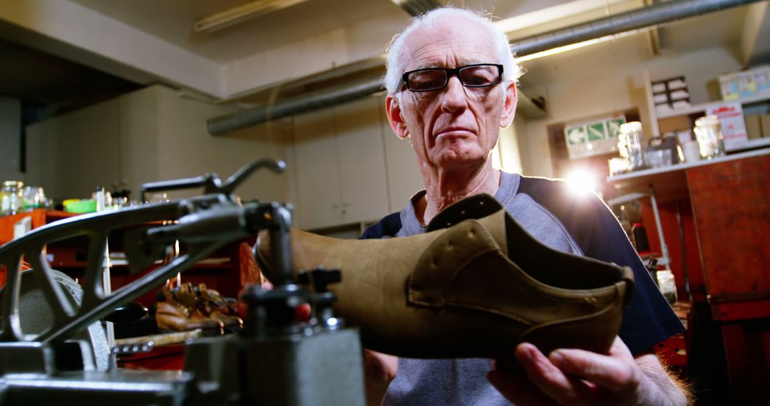 Elderly Craftsperson Inspecting a Shoe in a Workshop - Free Images, Stock Photos and Pictures on Pikwizard.com