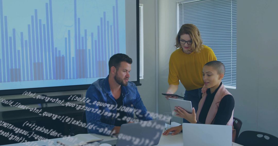 Collaborating team reviewing bar chart and analyzing data on tablet and laptop screens