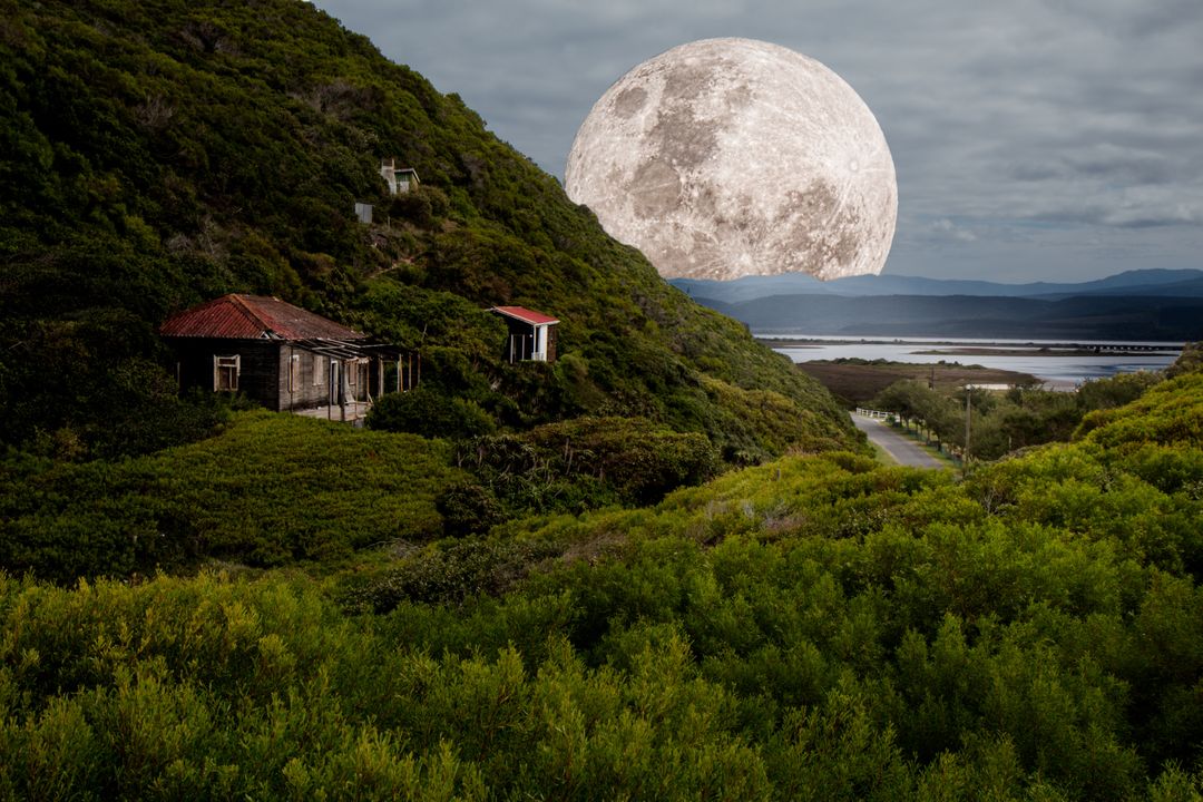 Giant Moon Over Rustic Cabins in Lush Green Valley - Free Images, Stock Photos and Pictures on Pikwizard.com