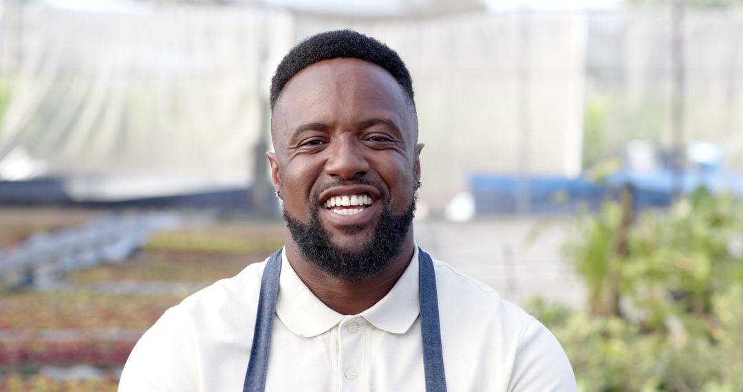 Smiling Horticulturist in Greenhouse with Trays