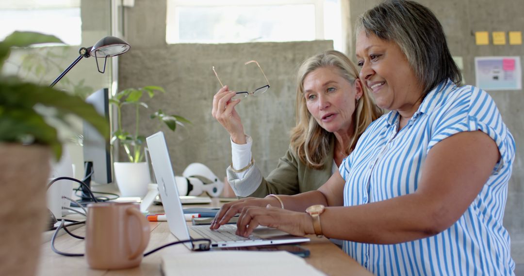 Diverse Female Colleagues Collaborating at Modern Office Workspace