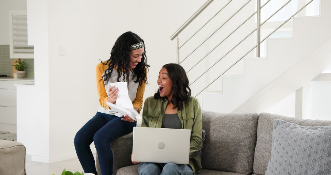 Mother and Daughter Using Laptop Together Discussing Documents