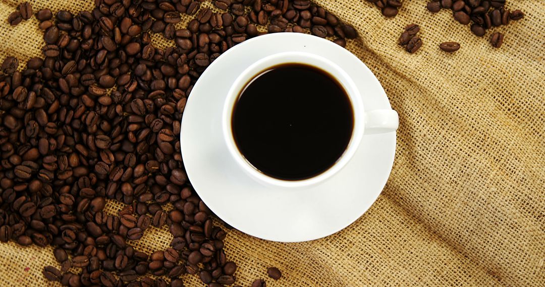 A white cup of black coffee and beans evokes morning vibes and coffee culture. - Free Images, Stock Photos and Pictures on Pikwizard.com