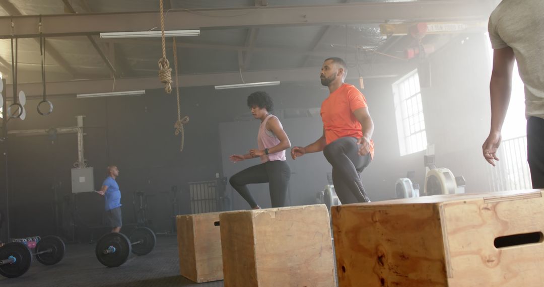 Diverse Group Training Box Jumps in Industrial Gym Setting