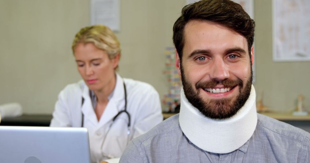 Man Wearing Neck Brace Smiling at Camera in Doctor's Office - Free Images, Stock Photos and Pictures on Pikwizard.com