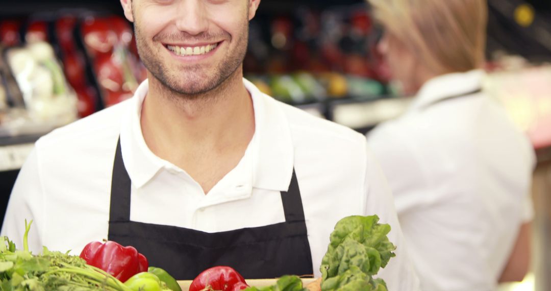 Smiling Grocery Worker Holding Fresh Vegetables in Store - Free Images, Stock Photos and Pictures on Pikwizard.com