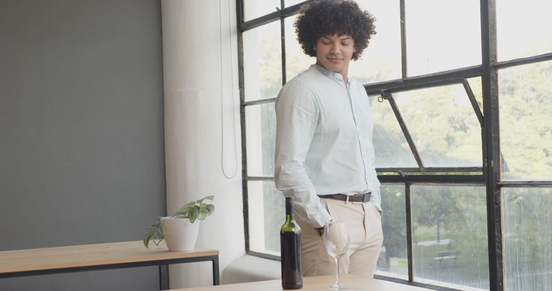 Young Man Relaxing by Office Window with Wine