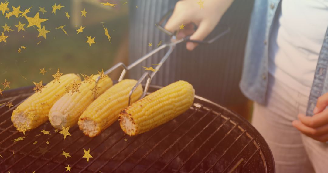 Grilling Corn on Barbecue with Golden Sparkles Overlay