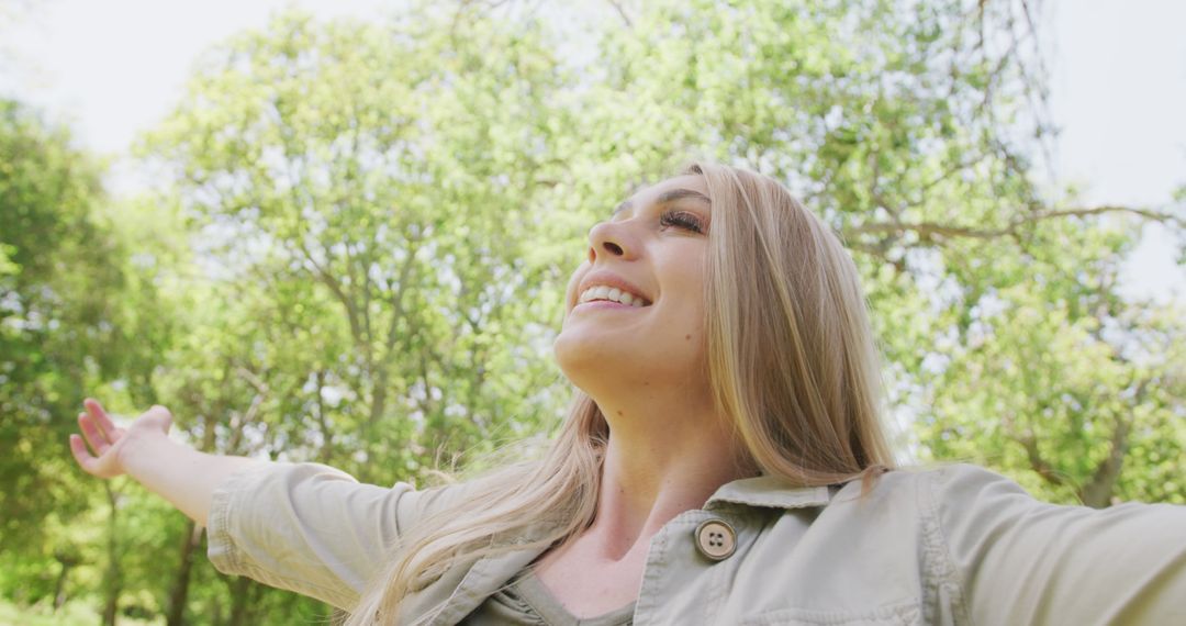 Joyful Woman Embracing Nature in Forested Park - Free Images, Stock Photos and Pictures on Pikwizard.com