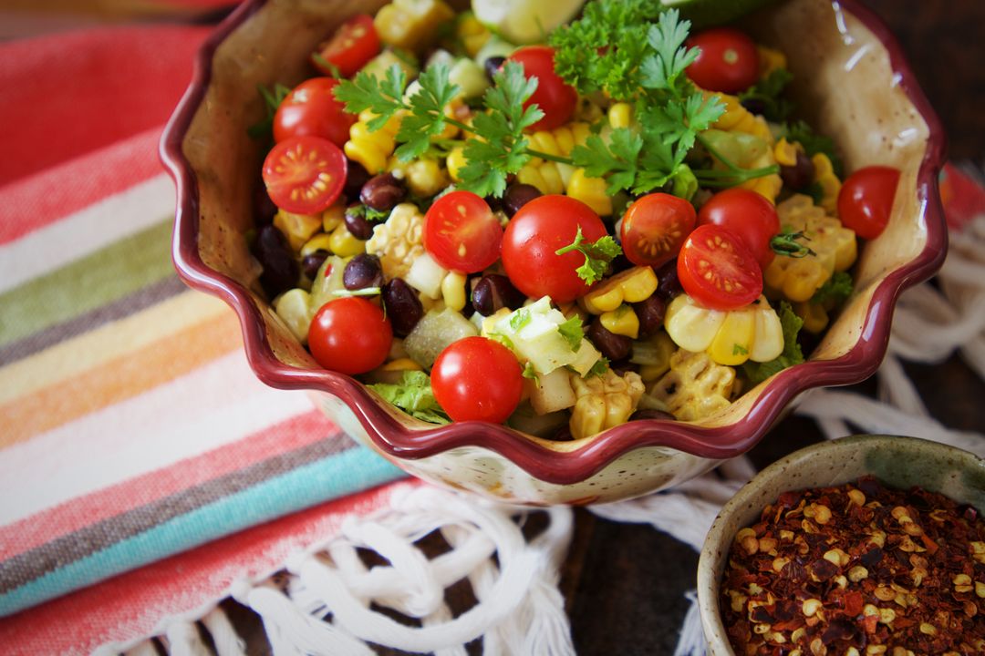Fresh Summer Corn and Black Bean Salad with Cherry Tomatoes and Cilantro in Rustic Ceramic Bowl
