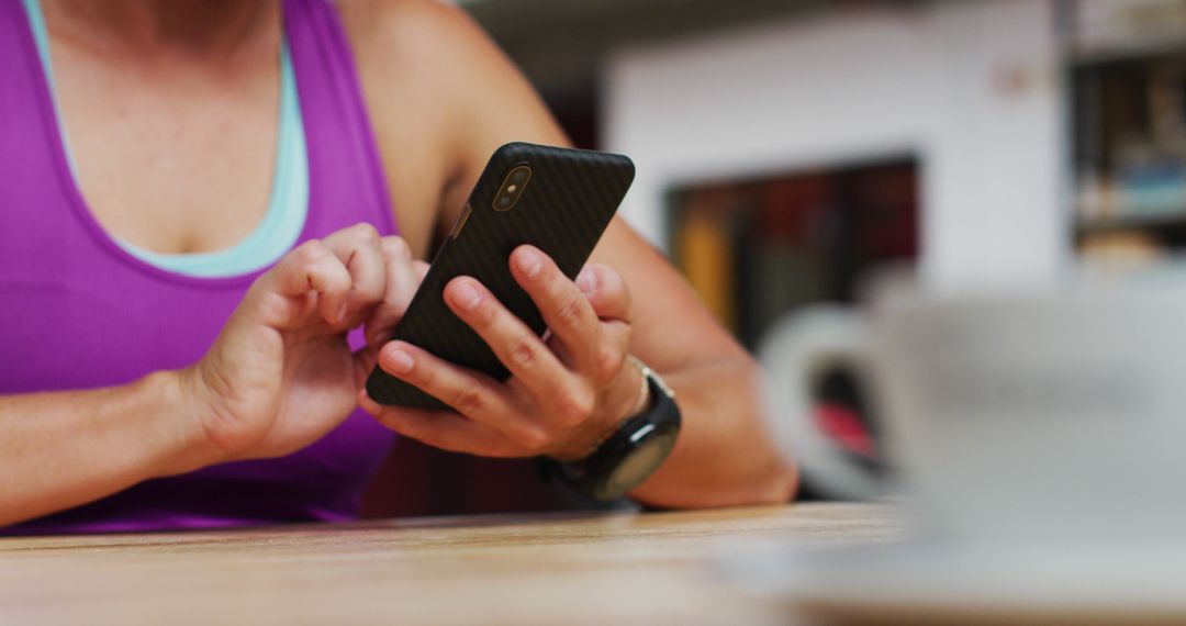 Person Using Smartphone in Gym Wearing Sportswear - Free Images, Stock Photos and Pictures on Pikwizard.com