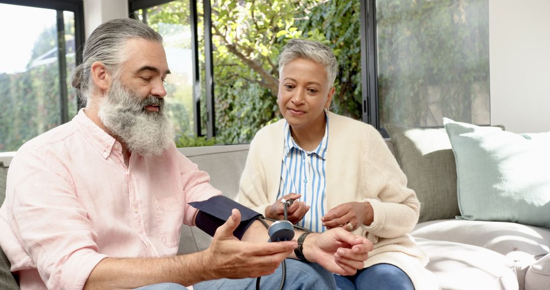 Senior Couple Monitoring Blood Pressure Using Digital Device at Home