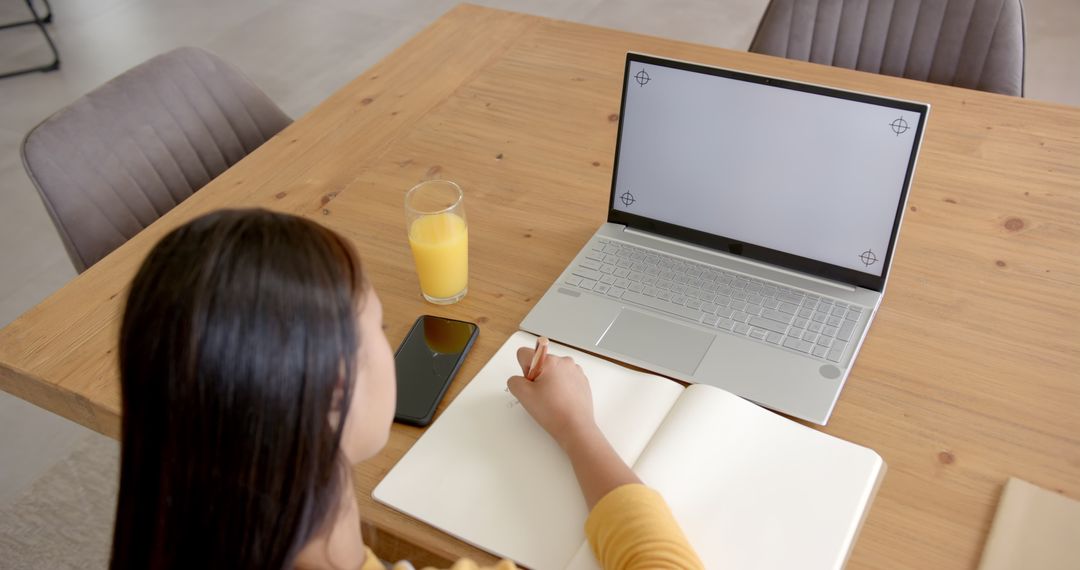 Focused Woman Studying With Laptop and Notepad Completing Important Task