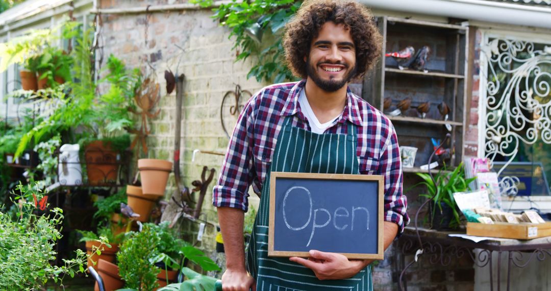 Happy Plant Shop Owner Holding Open Sign in Garden Store - Free Images, Stock Photos and Pictures on Pikwizard.com