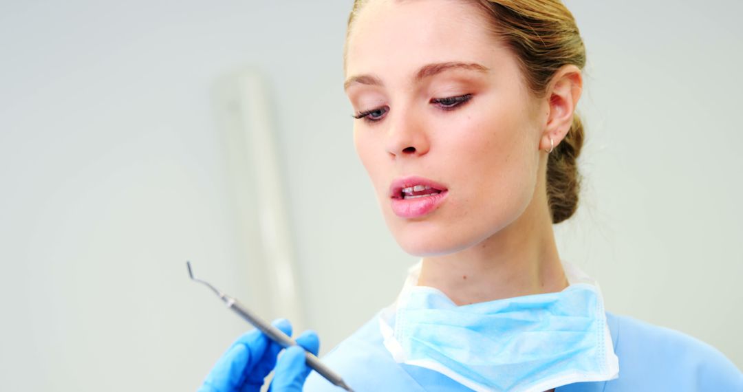 Focused Female Dentist Examining Dental Instrument - Free Images, Stock Photos and Pictures on Pikwizard.com