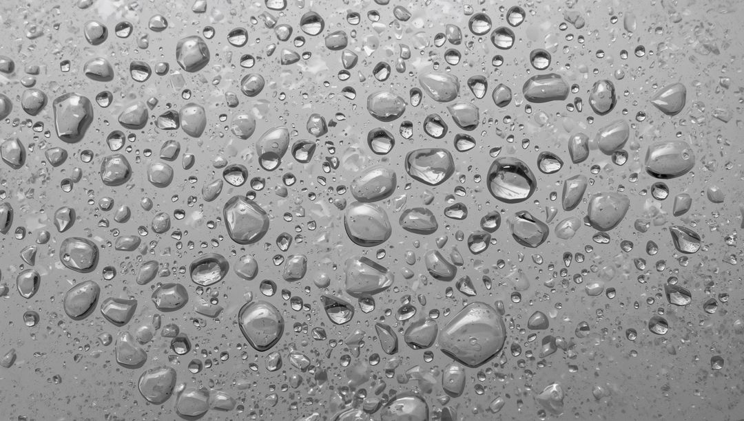 Close-up Water Droplets on Glass Pane Creating Reflective Macro Texture Pattern