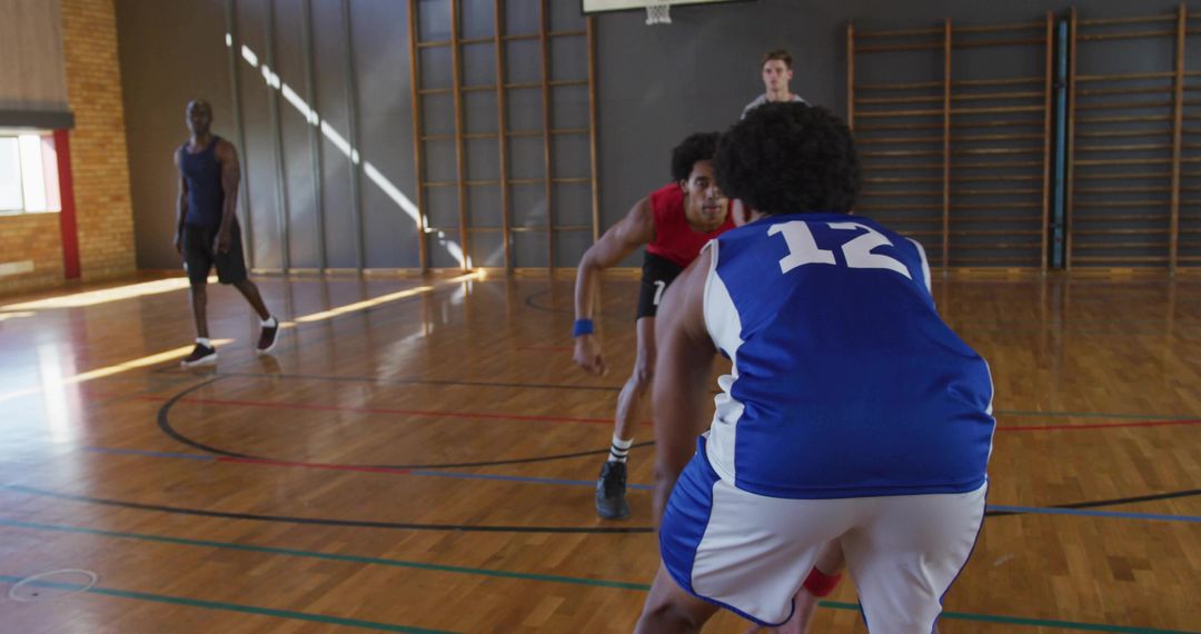 School Basketball Player Number 12 Dribbling While Defender Pressuring on Hardwood Court