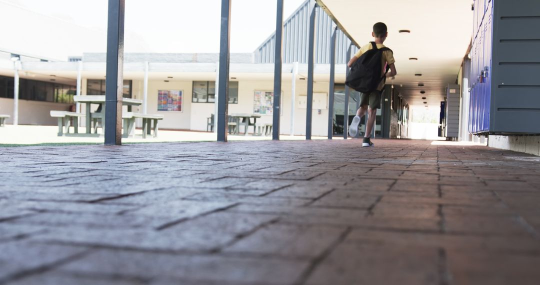 Student with Backpack Walking in School Corridor