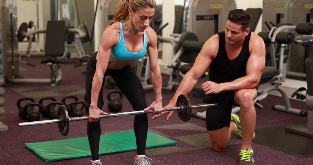 Woman Receiving Guidance from Fitness Trainer During Weightlifting Session - Free Images, Stock Photos and Pictures on Pikwizard.com