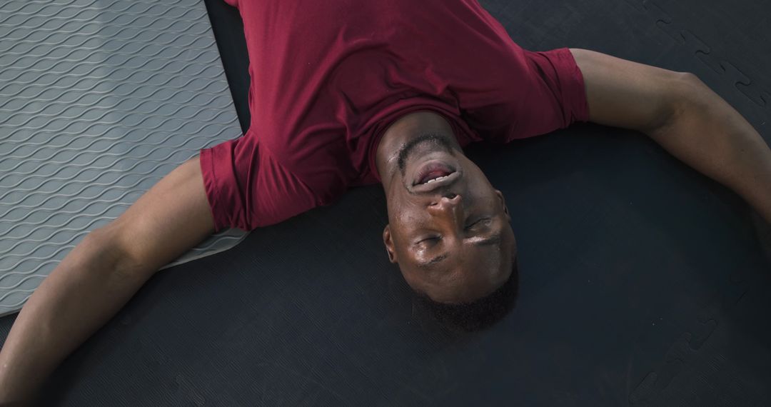 Exhausted Athlete Resting on Gym Floor After Intensive Workout