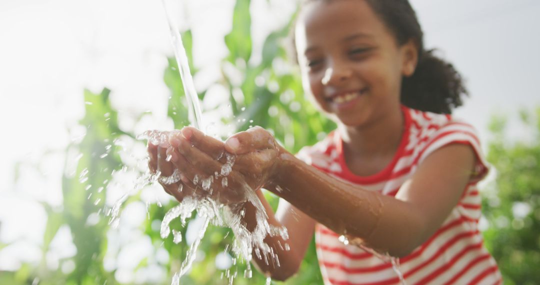 Smiling african american girl washing hands in garden after gardening - Free Images, Stock Photos and Pictures on Pikwizard.com