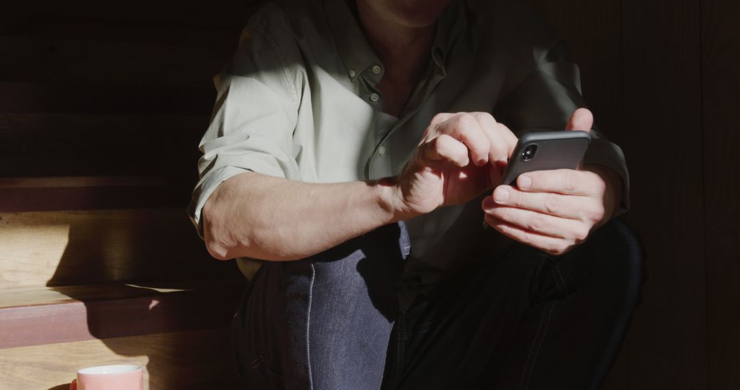 Man Sitting on Stairs Using Smartphone in Sunlight - Free Images, Stock Photos and Pictures on Pikwizard.com