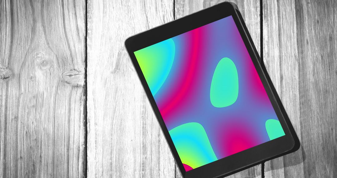 Tablet Displaying Colorful Digital Shapes on Wooden Table