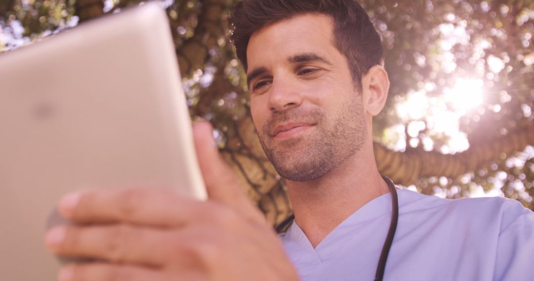 Smiling Healthcare Worker Using Tablet Outdoors - Free Images, Stock Photos and Pictures on Pikwizard.com