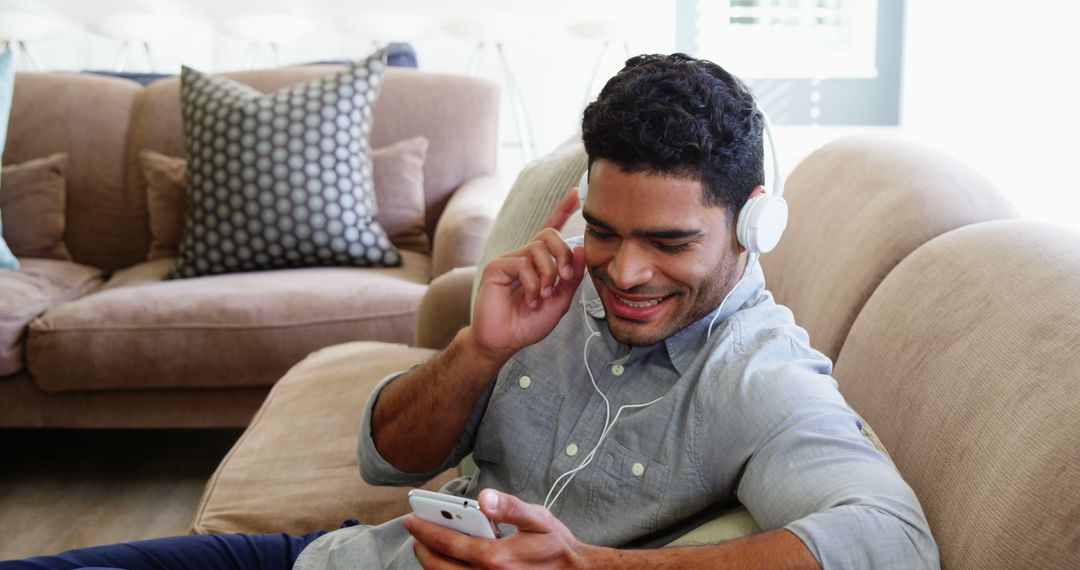 Smiling Man Relaxing on Couch with Headphones and Smartphone - Free Images, Stock Photos and Pictures on Pikwizard.com