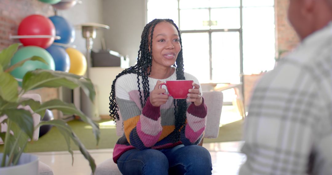 Young Woman Holding Coffee Cup in Modern Living Room - Free Images, Stock Photos and Pictures on Pikwizard.com