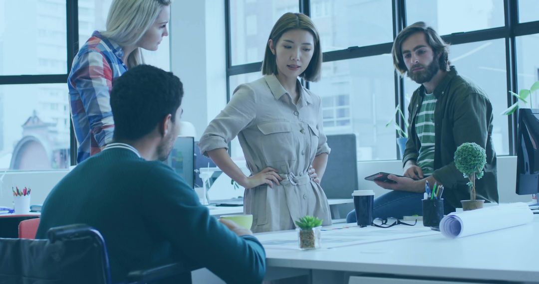 Team Collaborating at Open-Plan Office for Dynamic Project Discussion
