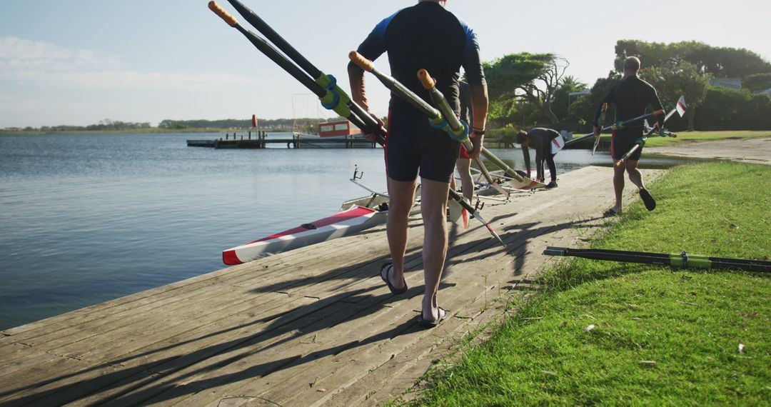 Team Preparing Canoes by Riverside on Sunny Day - Free Images, Stock Photos and Pictures on Pikwizard.com